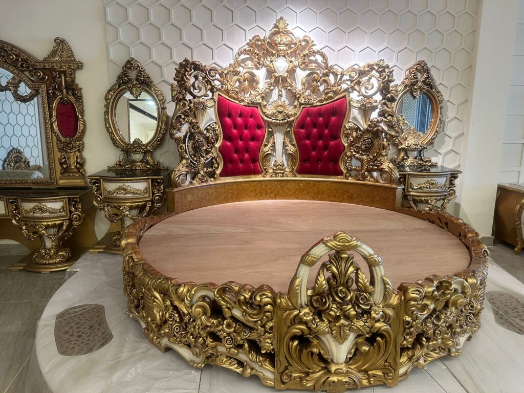 Royal round bed design with golden and white finish and maroon upholstery