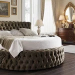 velvet bed frame of a round bed along with two side tables and dressing .